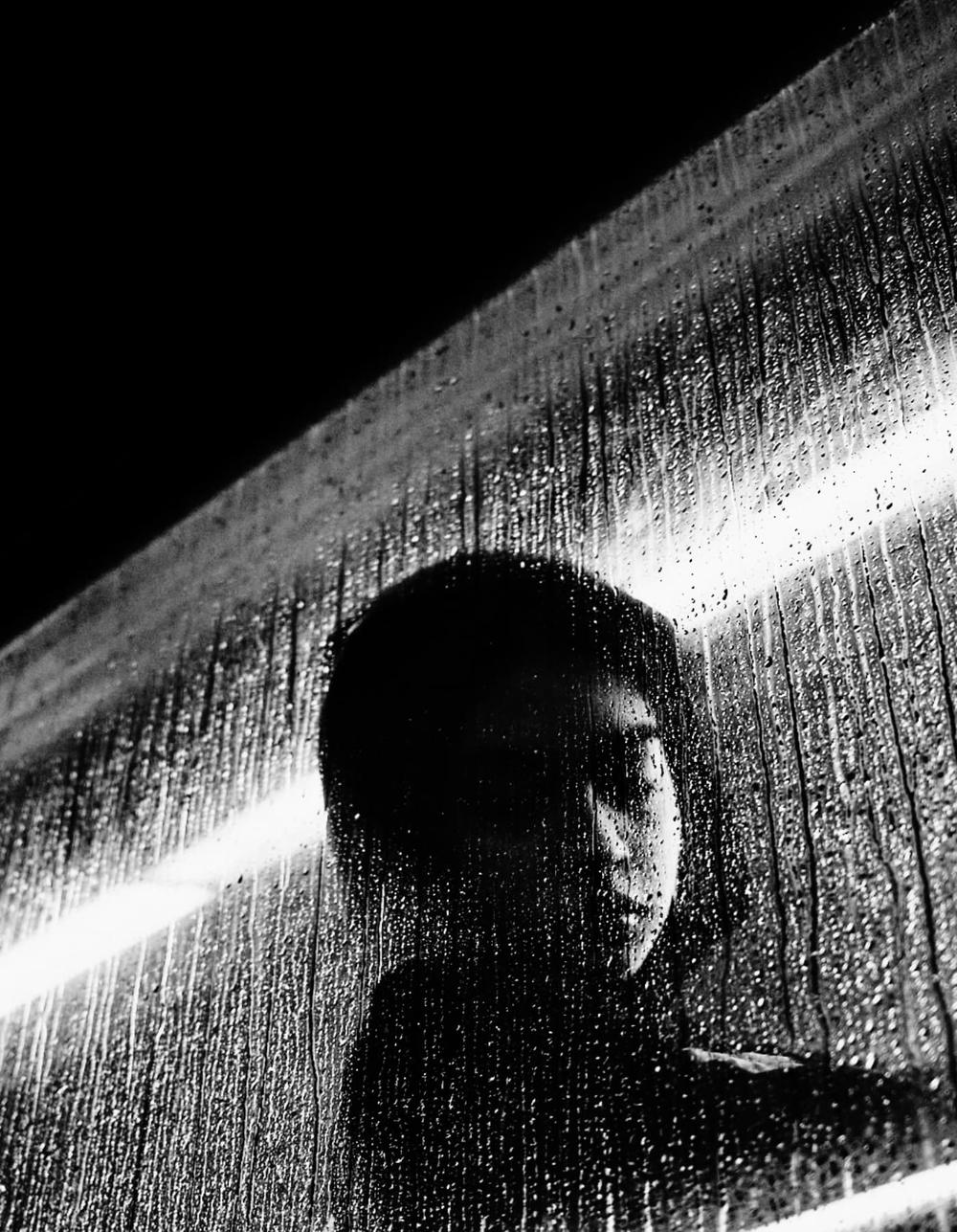 Street portrait through rain-streaked glass — JayRegular